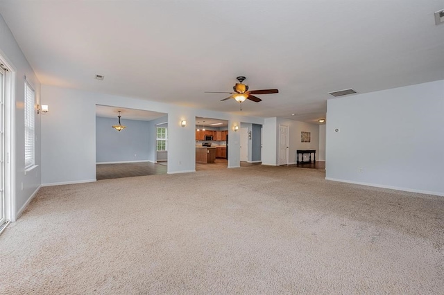 unfurnished living room with ceiling fan and carpet floors