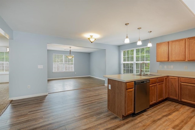 kitchen with pendant lighting, dishwasher, kitchen peninsula, sink, and wood-type flooring