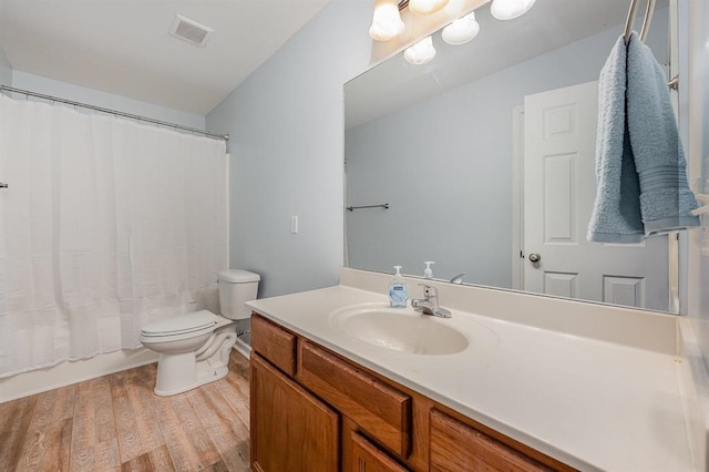 full bathroom with shower / bath combo, vanity, hardwood / wood-style flooring, and toilet