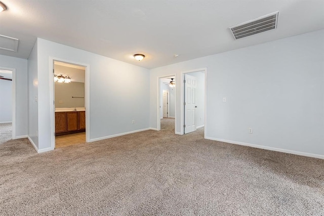 unfurnished bedroom featuring ensuite bath and light carpet