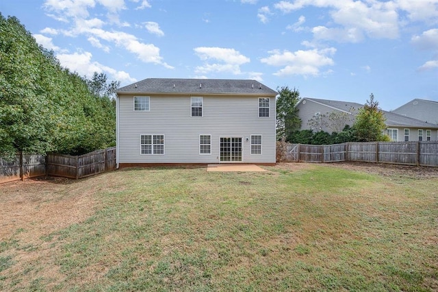 back of property with a lawn and a patio