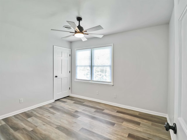 empty room with ceiling fan and wood-type flooring