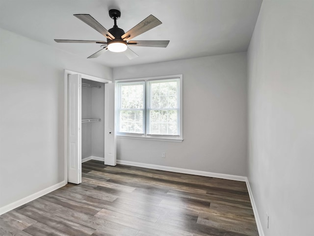 unfurnished bedroom featuring ceiling fan, a closet, and dark hardwood / wood-style floors