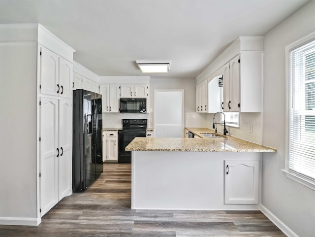 kitchen with white cabinetry, sink, dark wood-type flooring, kitchen peninsula, and black appliances