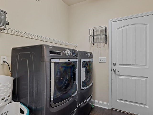 clothes washing area featuring independent washer and dryer and dark wood-type flooring