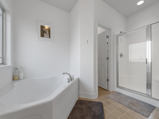 bathroom featuring shower with separate bathtub