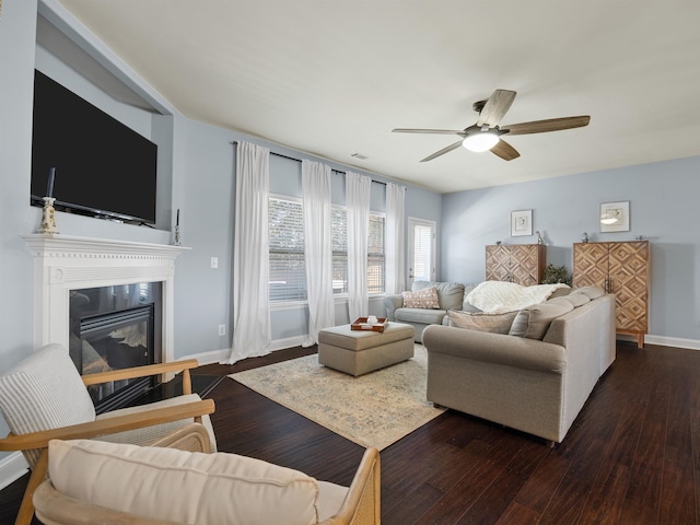 living room featuring ceiling fan and dark hardwood / wood-style floors