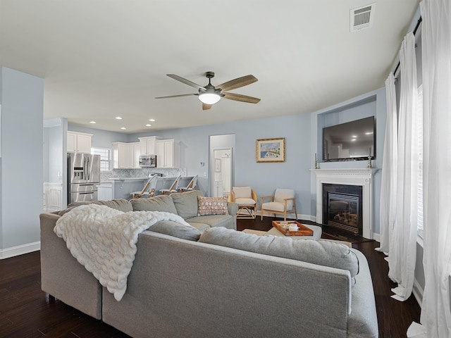 living room with dark hardwood / wood-style floors and ceiling fan