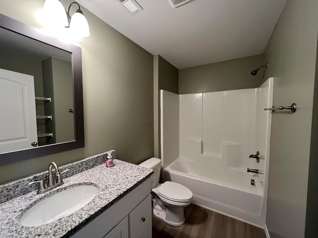 full bathroom featuring washtub / shower combination, vanity, hardwood / wood-style flooring, and toilet