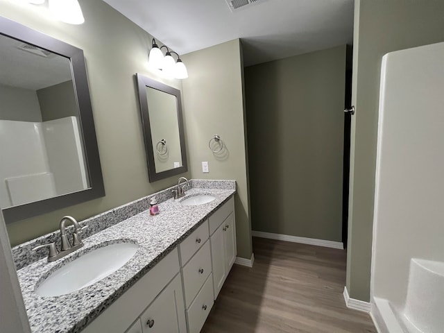 bathroom with hardwood / wood-style floors, vanity, and walk in shower