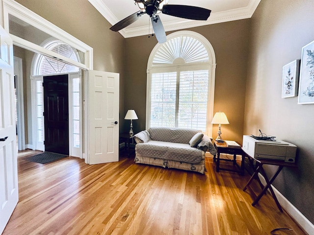 interior space with hardwood / wood-style floors, ceiling fan, and ornamental molding