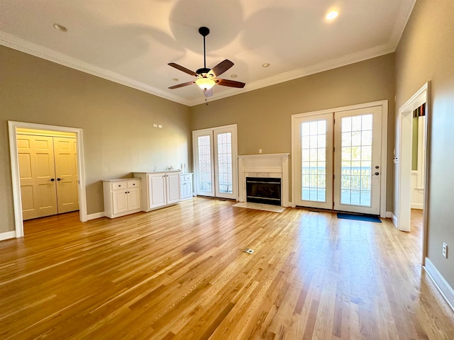 unfurnished living room featuring ceiling fan, light hardwood / wood-style floors, and ornamental molding