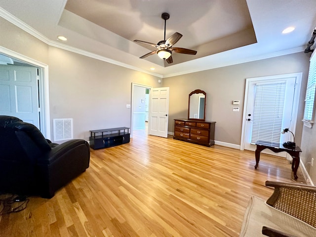 living area with light hardwood / wood-style floors and crown molding