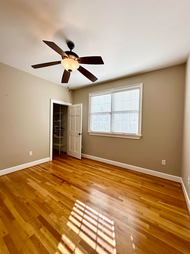 unfurnished bedroom featuring ceiling fan, light hardwood / wood-style flooring, and a closet