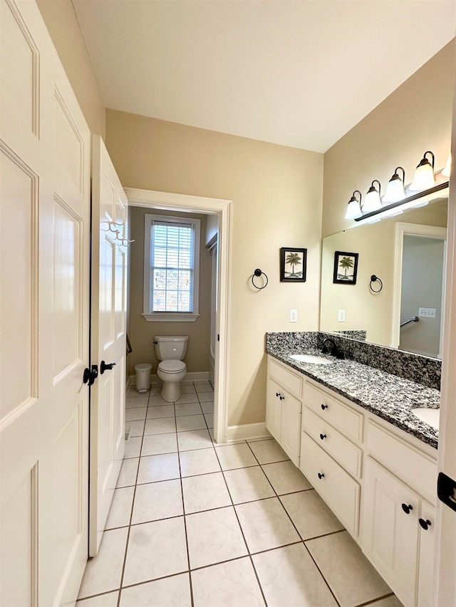 bathroom with tile patterned flooring, vanity, and toilet