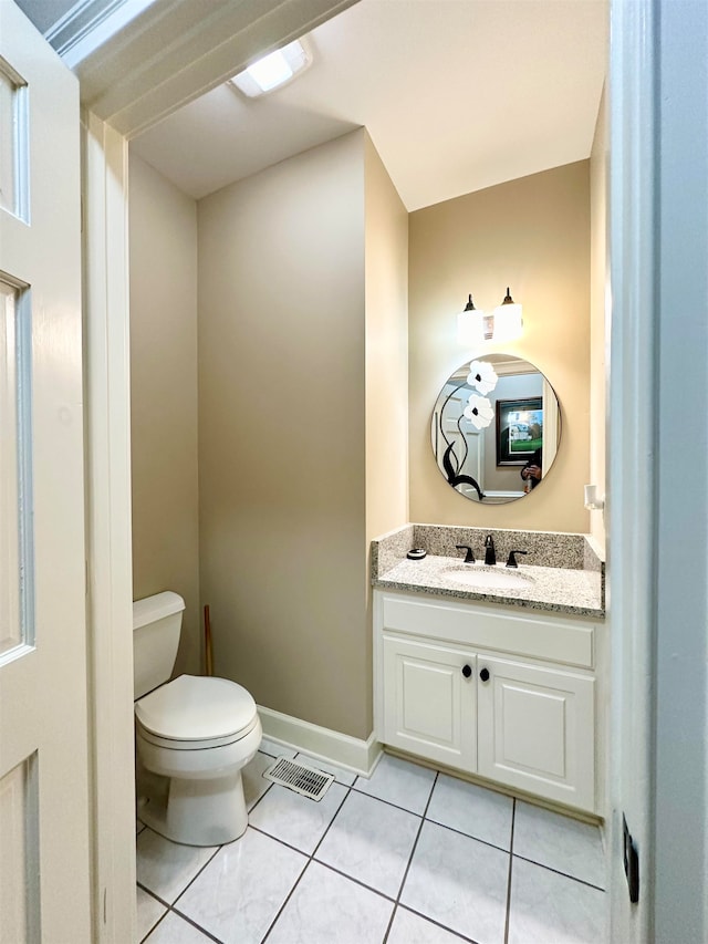 bathroom featuring tile patterned flooring, vanity, and toilet