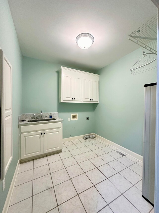 clothes washing area with sink, cabinets, washer hookup, hookup for an electric dryer, and light tile patterned floors