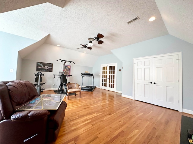 sitting room featuring hardwood / wood-style floors, a textured ceiling, vaulted ceiling, and ceiling fan