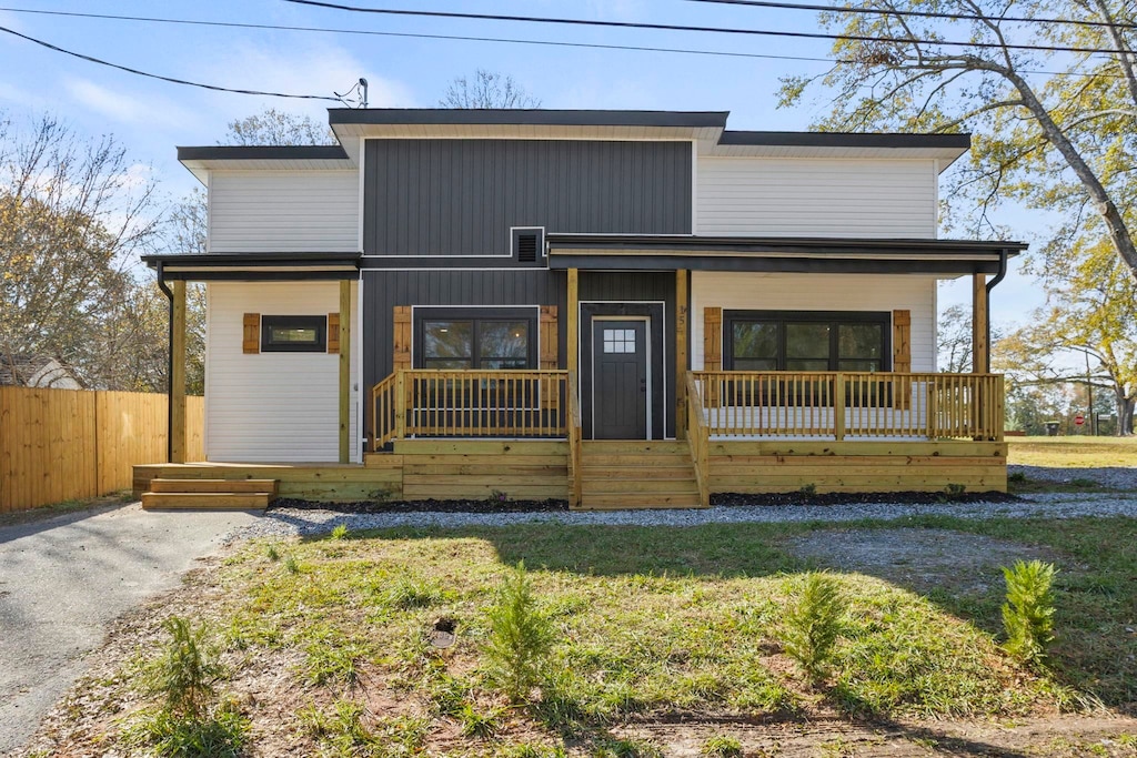 view of front of house featuring covered porch and a front lawn