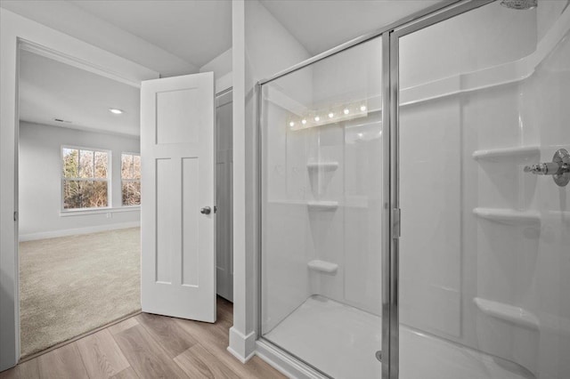 bathroom with walk in shower and hardwood / wood-style floors