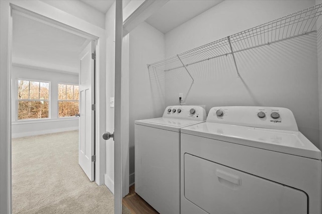 clothes washing area featuring separate washer and dryer and light colored carpet