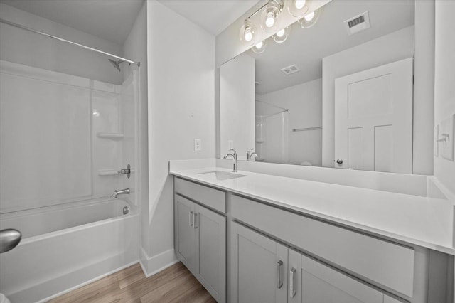 bathroom featuring wood-type flooring, vanity, and shower / bathing tub combination