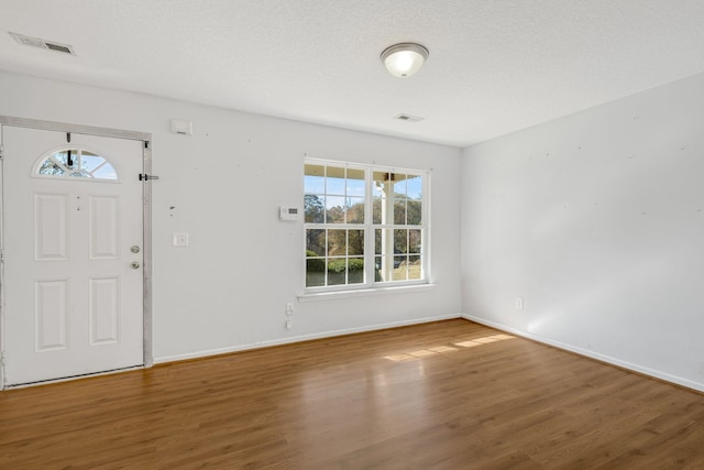 foyer with wood-type flooring and a textured ceiling