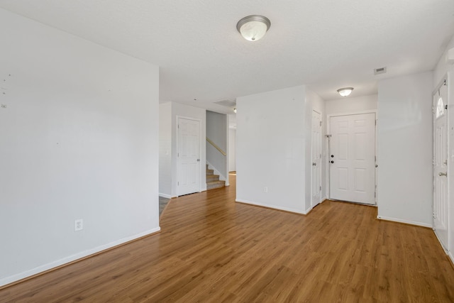 empty room featuring a textured ceiling and hardwood / wood-style flooring