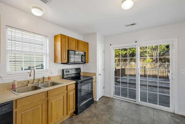 kitchen with a textured ceiling, sink, a healthy amount of sunlight, and black appliances