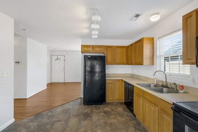 kitchen with dark wood-type flooring, sink, black appliances, and a textured ceiling