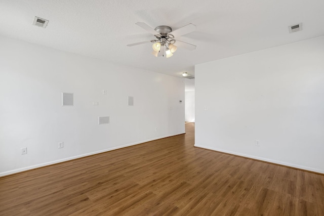 unfurnished room featuring ceiling fan, dark hardwood / wood-style flooring, and a textured ceiling