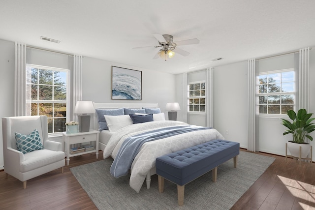 bedroom featuring multiple windows, ceiling fan, and dark hardwood / wood-style floors