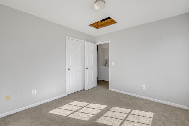 unfurnished bedroom featuring washer / dryer and light carpet