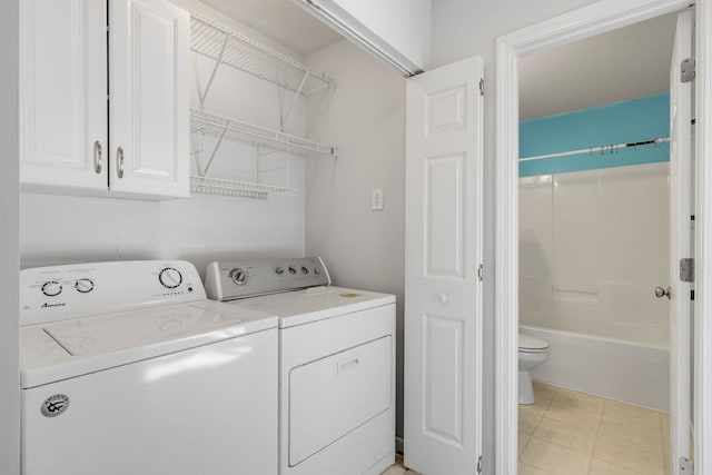 clothes washing area featuring cabinets and independent washer and dryer