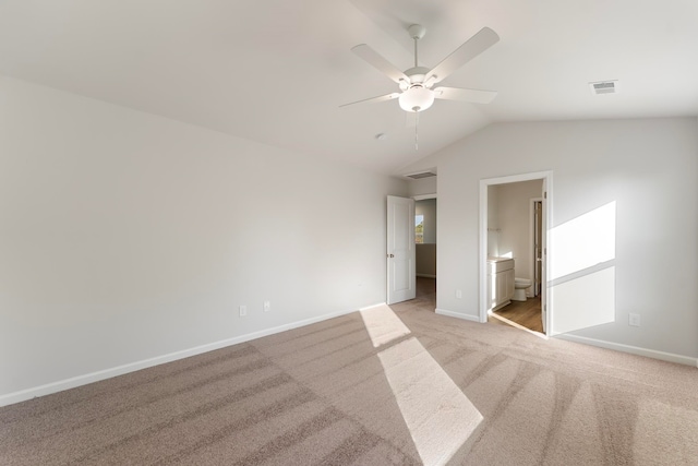 unfurnished bedroom featuring light carpet, connected bathroom, ceiling fan, and lofted ceiling