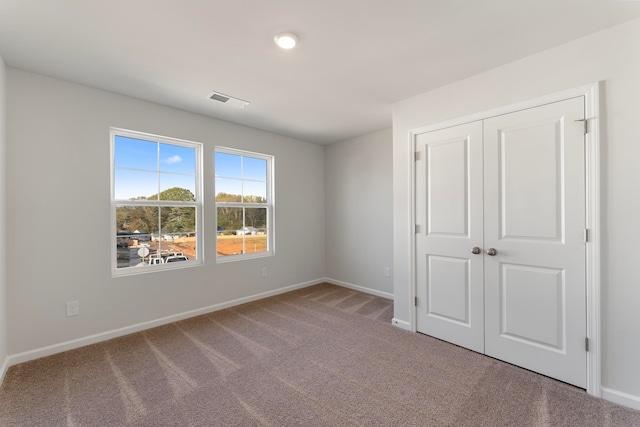 unfurnished bedroom with carpet floors and a closet