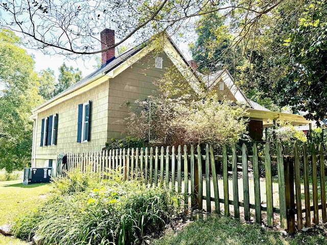 view of side of property with a yard and central air condition unit