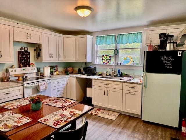 kitchen featuring dark hardwood / wood-style flooring, white cabinetry, sink, and white appliances