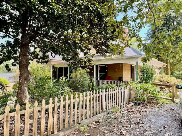 view of property hidden behind natural elements featuring a porch