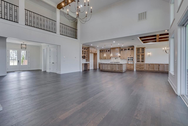 unfurnished living room with beamed ceiling, dark hardwood / wood-style floors, and a towering ceiling