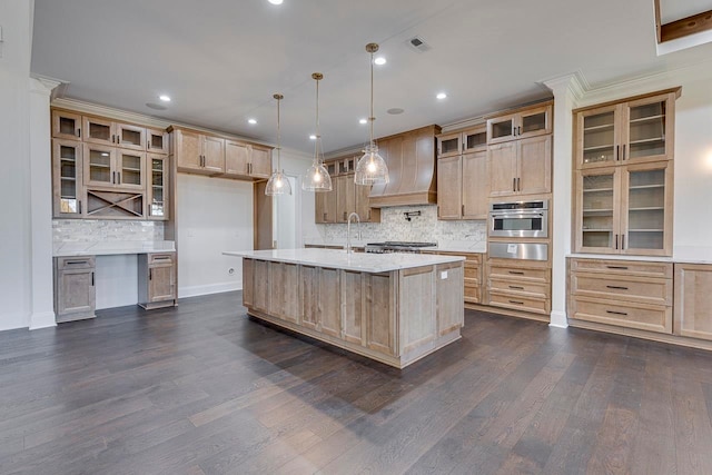 kitchen featuring oven, custom range hood, an island with sink, and dark wood-type flooring