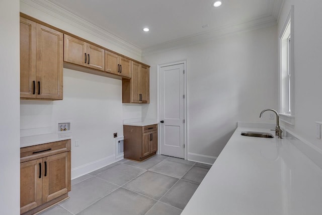 kitchen with crown molding, sink, and light tile patterned floors