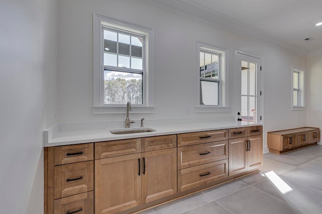 bathroom featuring tile patterned floors, crown molding, and sink