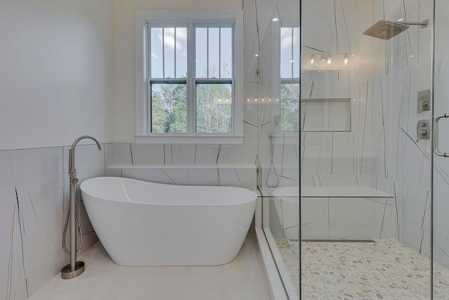 bathroom featuring separate shower and tub and tile walls