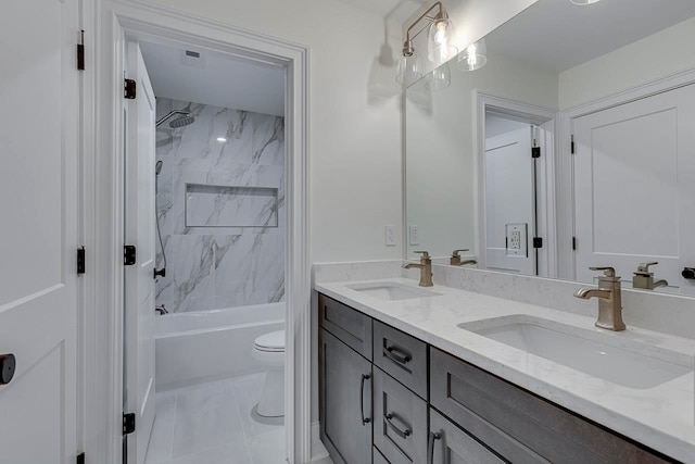 full bathroom with tile patterned floors, tiled shower / bath combo, toilet, and vanity