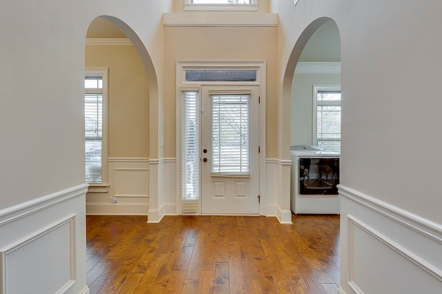 entrance foyer featuring hardwood / wood-style flooring, washer / clothes dryer, and ornamental molding