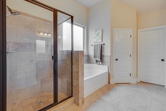 bathroom with tile patterned floors and shower with separate bathtub