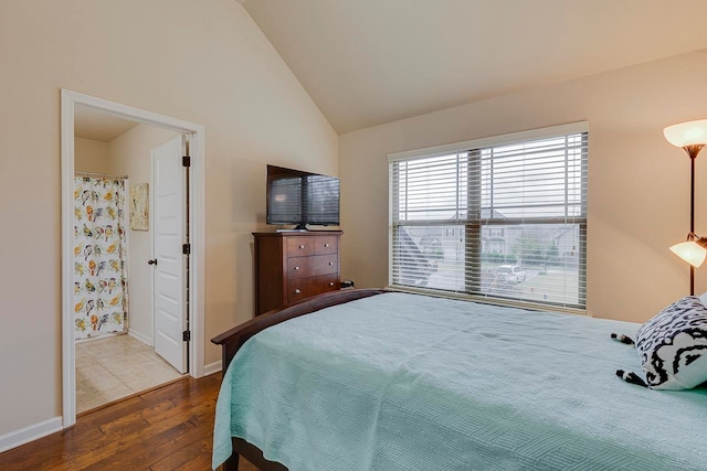 bedroom featuring connected bathroom, dark hardwood / wood-style floors, and lofted ceiling