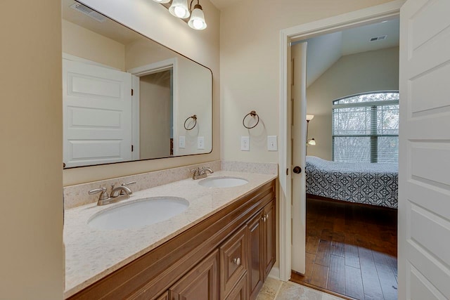 bathroom with vanity, hardwood / wood-style flooring, and vaulted ceiling