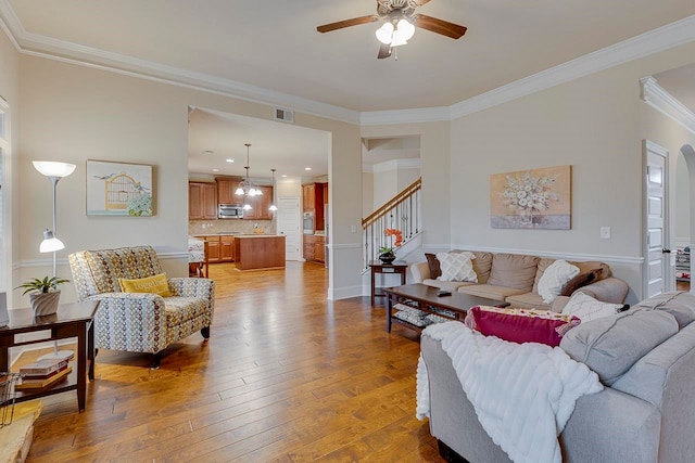 living room with hardwood / wood-style floors, ceiling fan, and ornamental molding